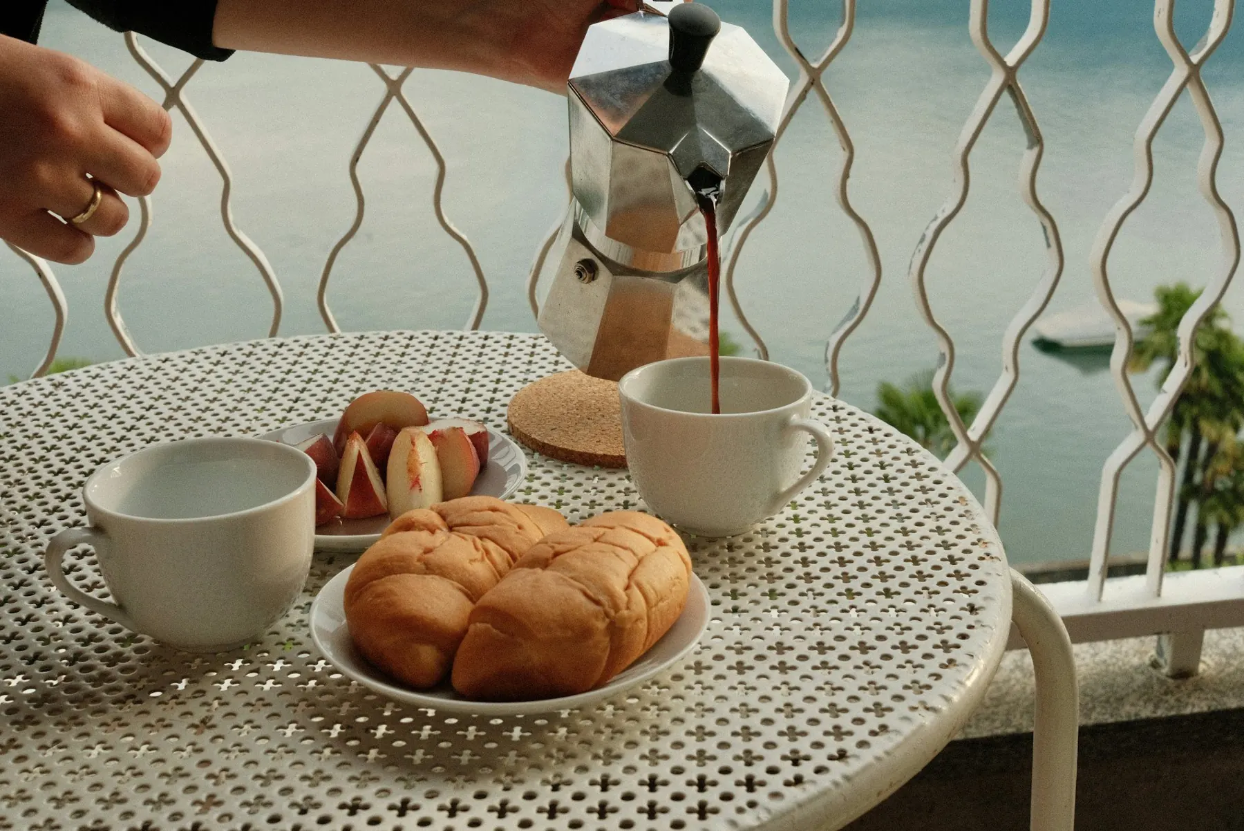 Un café versé au petit-déjeuner, sur un balcon face au lac